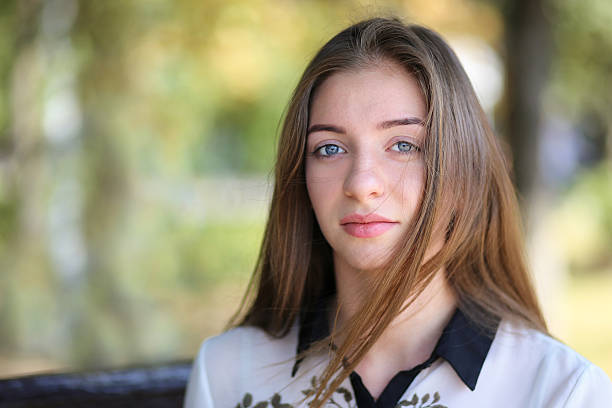 Young student girl relaxing in park at summer day. Portrait of pretty caucasian woman with copy space