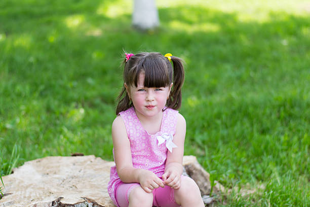 istock little girl in a park on a stump 497414237