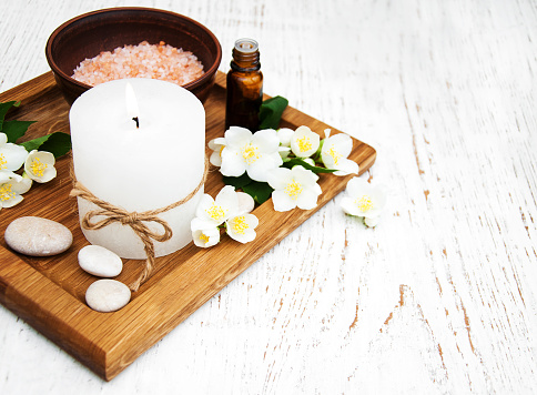 essential oil with jasmine flower on a wooden background