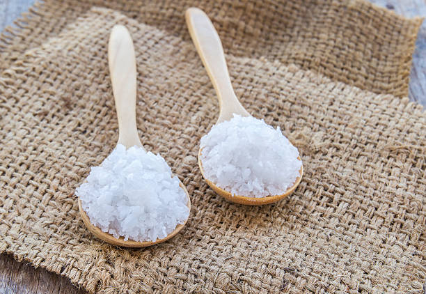 istock Sea salt in wooden spoon on burlap sack 497415342