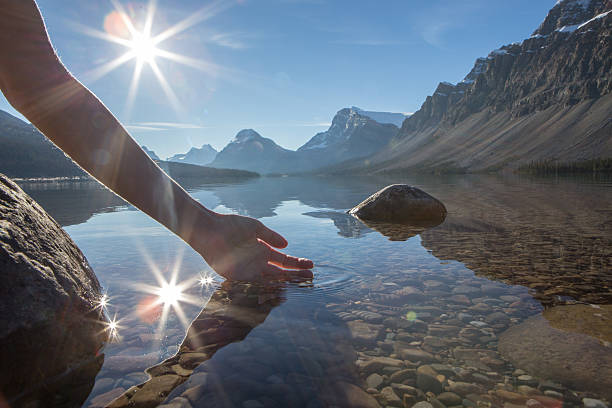 umani mano a pugno di prendere le fresche acque del lago - bow lake foto e immagini stock