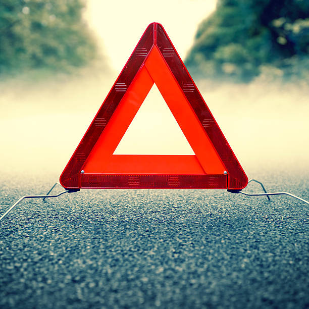 istock Bad weather driving - warning triangle on a foggy road 497416349