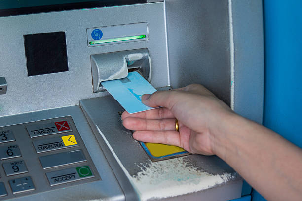 istock Hand inserting ATM credit card into bank machine 497418240