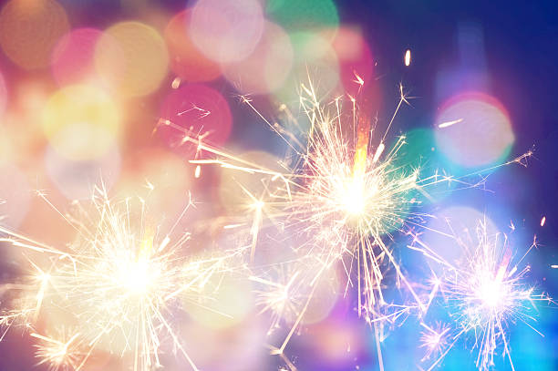 istock Burning christmas sparkler on colorful light background 497419770