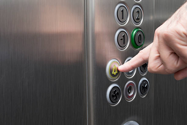 указательного пальца, нажав на кнопку «будильник» в лифте - elevator push button control panel moving up стоковые фото и изображения