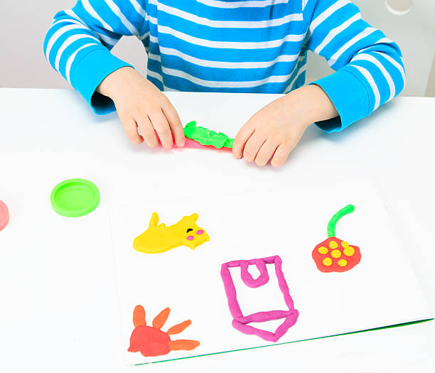 istock little boy playing with clay dough, education and daycare 497421064