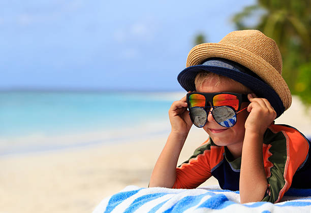 istock cute little boy trying on sunglasses at beach 497421324