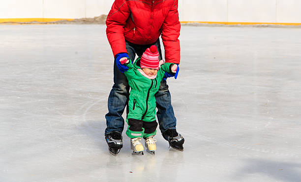 istock father and child learning to skate in winter 497421436