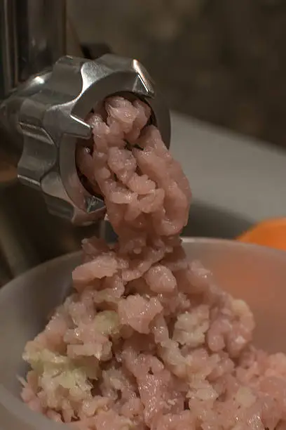 chopper chopping meat, close-up pink and minced meat grinder.