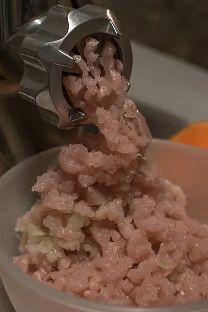 chopper chopping meat, close-up pink and minced meat grinder.