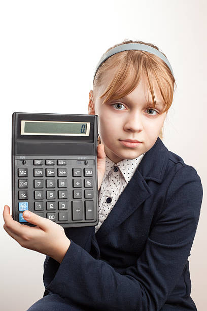 istock Little blond schoolgirl with calculator above white 497430431