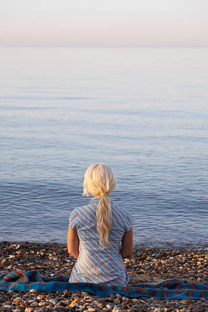 istock Woman Sitting On Seaside At Beach 497435815
