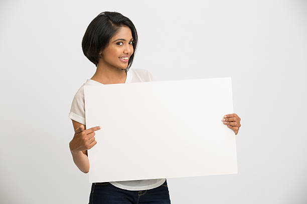 istock Happy young Indian woman holding a blank billboard 497438180