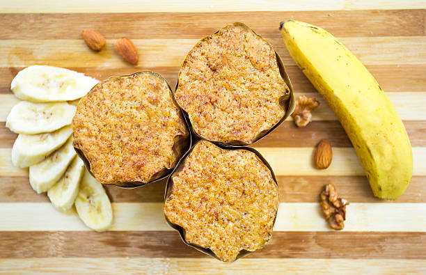 банановый хлеб cupcake на столе с бананом и орехами. - alenka стоковые фото и изображения