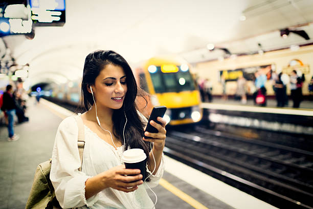 joven mujer usando el teléfono en la estación de tren de sydney - financial district audio fotografías e imágenes de stock