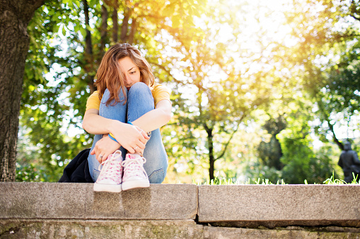 Teenage girl feeling depressed in the park