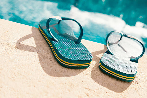istock blue flip-flops at edge of summer swimming pool 497442114