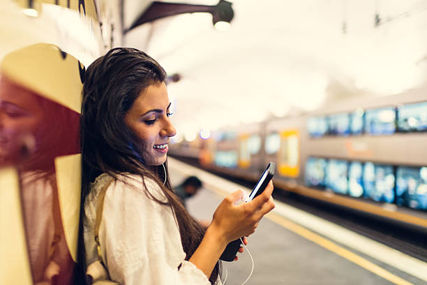 Young woman using a phone at train station in Sydney stock photo