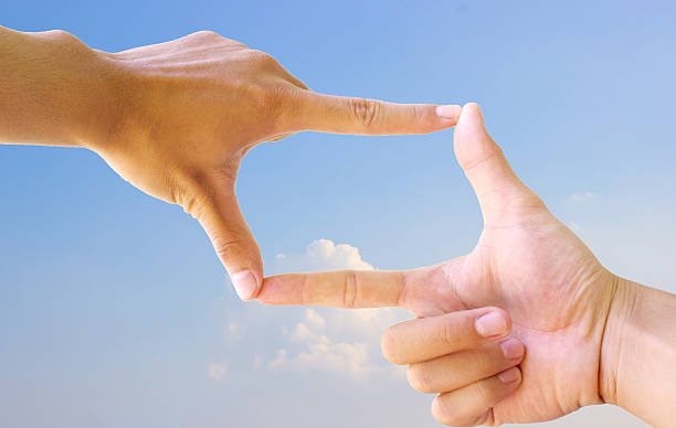 istock Photo sight:Frame made of hands with sunset sky 497443236