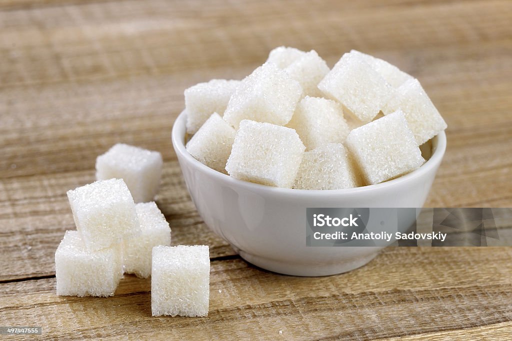 Sugar cubes in bowl Sugar cubes in bowl on wooden table Bowl Stock Photo