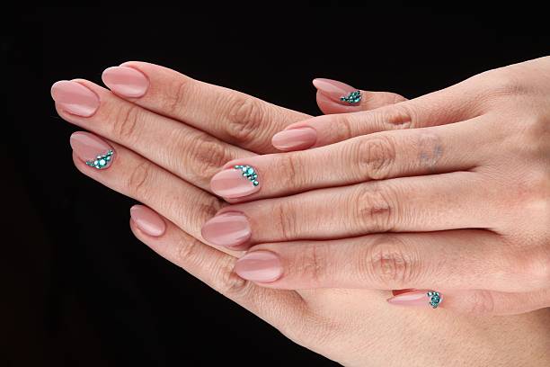 istock pained nails with cristals and hands isolated on black background 497447715