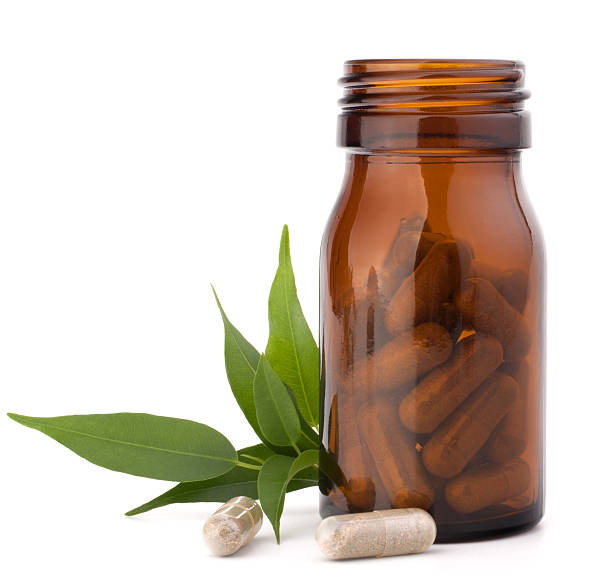 capsule di farmaco a base di erbe in bottiglie di vetro marrone.  medicina alternativa - antibiotic pain cut out bottle foto e immagini stock