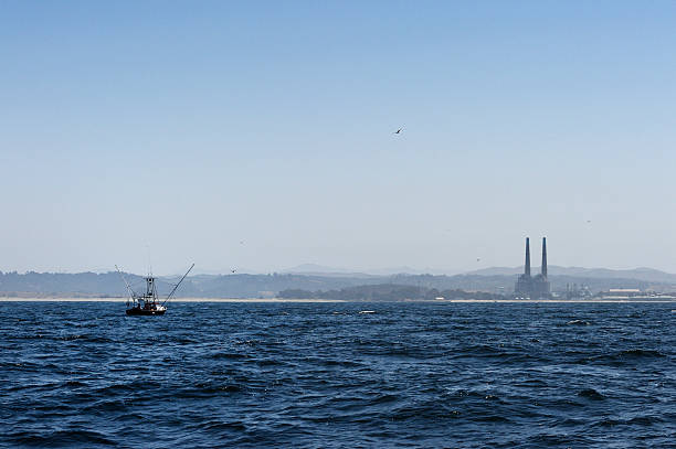 istock Fishing Boat with Power Plant in Background 497450529