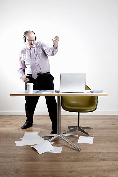 istock Businessman Wearing Headphones While Playing Air Guitar 497451037