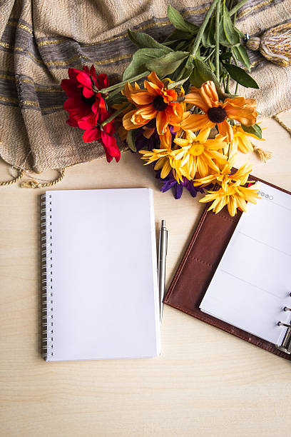 istock Notepad,pencil and flowers on the wood table. 497454145