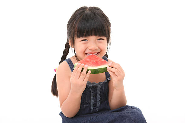 istock Little girl eating fruit 497467309