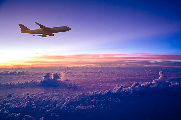 istock Airplane in the sky at sunrise 497471021