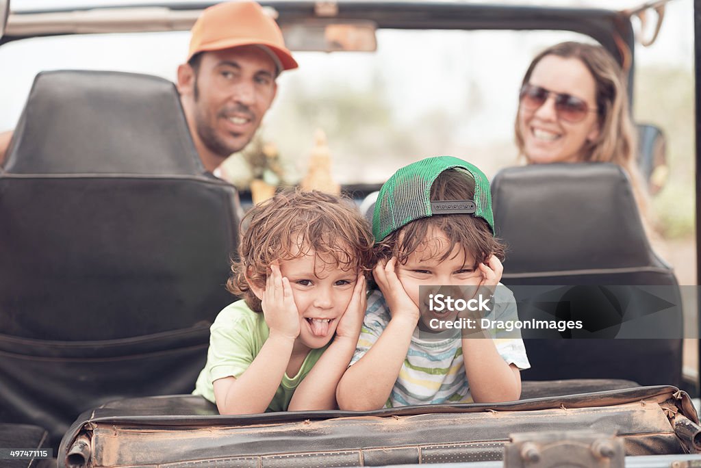 Making faces Two small brothers making faces while sitting in the off-road car Back Seat Stock Photo