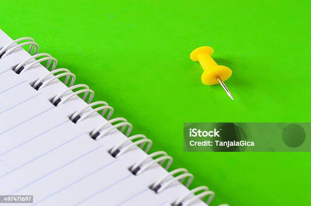 Agenda And Yellow Push Pin Isolated On Green Background Stock Photo - Download Image Now