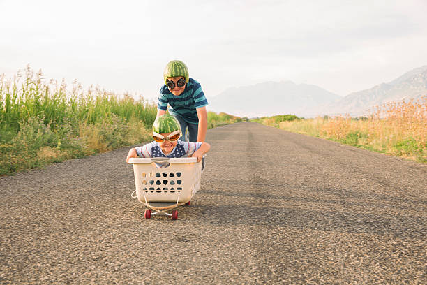 istock Young Boys Racing on Skateboard Wearing Watermelon Helmets 497478944