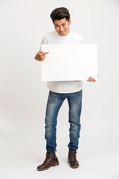 istock Happy smiling young Indian man holding a blank billboard 497479638