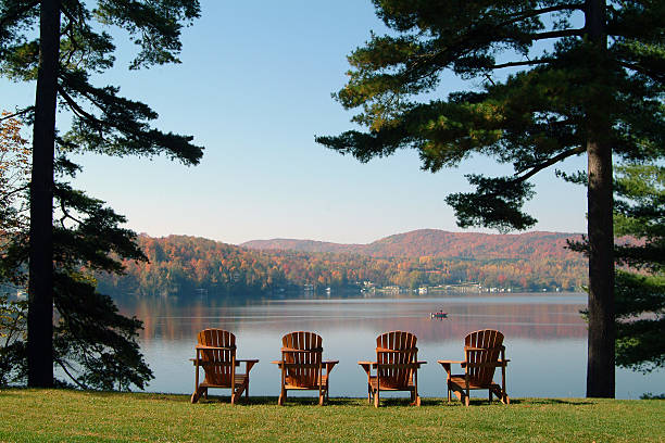 View of the lake in autumn 4 chairs facing the beautiful lake Massawippi in the Eastern Townships, Québec. Photo taken on a calm tranquil colorful morning during the peak autumn foliage season in Ayers Cliff, Quebec. chalet stock pictures, royalty-free photos & images