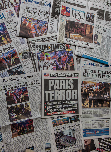 Carol Stream, IL, USA, November 17, 2015: A pile of local and national newspapers, many of them with headlines on the front pages reporting stories in the days immediately following the Terrorist attack in Paris, France.