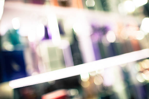 Defocused and toned fragrance bottles in store display. Slight grain effect in shadow areas.