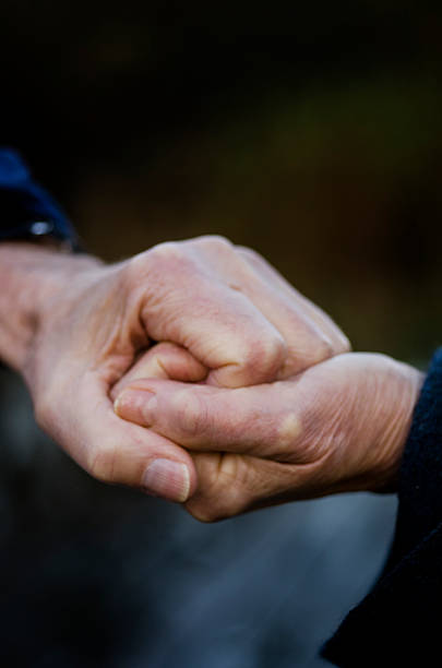 istock Old couple grapping eachothers hands, closeup 497483742