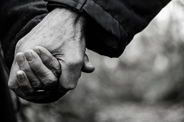 istock Senior married couple holding hands closeup 497486296