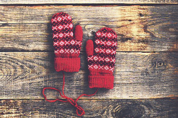 istock Pair of red woolen mittens on wooden background 497487704
