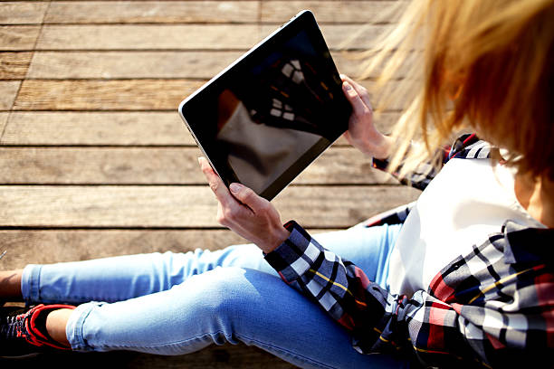 istock Woman watching video on digital tablet during her summer weekend 497488466