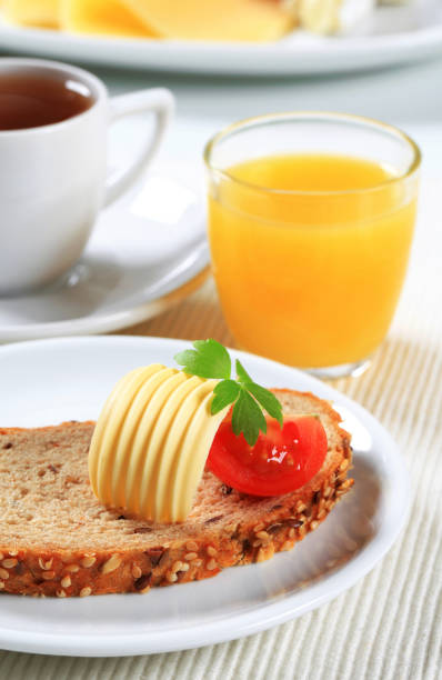 Bread with butter, cup of tea and orange juice