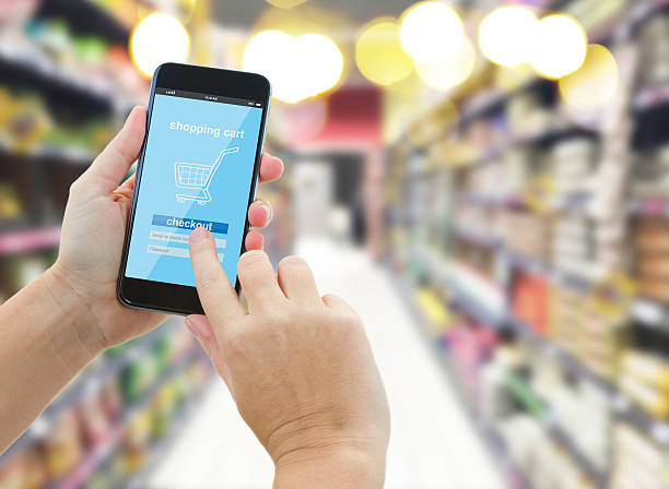 istock hand holding a modern smartphone in supermarket 497488926