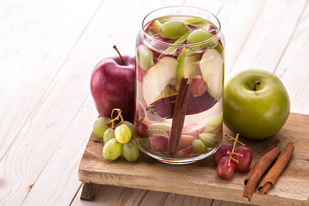 mistura de água com infusão de sabores de maçã, uvas e canela - apple red fruit water - fotografias e filmes do acervo