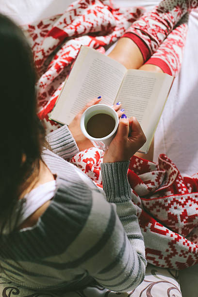 istock Girl in bed with coffee cup reading a book 497490096