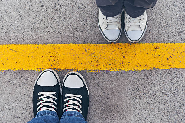 Sneakers from above. Sneakers from above. Male and female feet in sneakers from above, standing at dividing line. boundary stock pictures, royalty-free photos & images