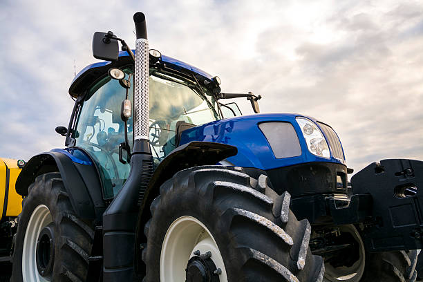 istock Blue tractor with weather cloudy sky. 497490654
