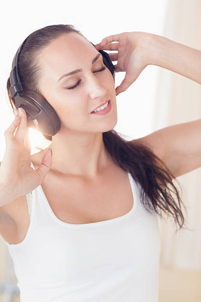 istock Peaceful brunette sitting on bed listening to music 497492863