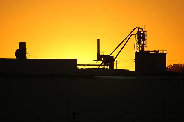 Waiting for sunrise behind factory equipment